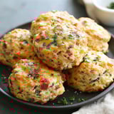 A plate of biscuits with green toppings.