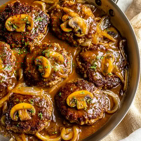 A pan of meat with mushrooms and onions.
