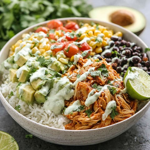 A bowl of food with rice, beans, corn, tomatoes, lime, and avocado.